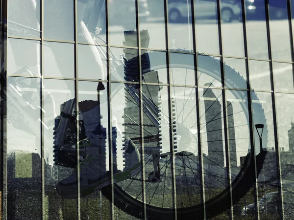 Double exposure of bike wheel and cityscape