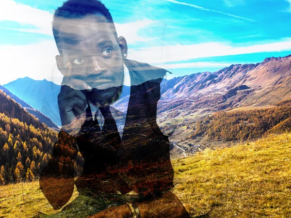 Double exposure of thoughtful businessman and mountain landscape