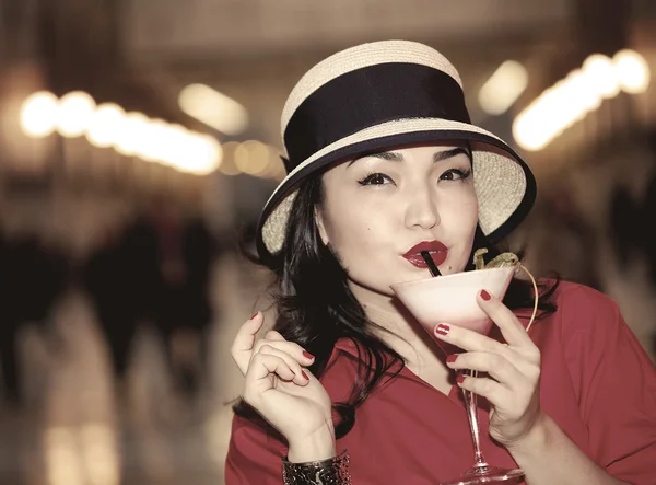 Vintage portrait of beautiful woman drinking cocktail
