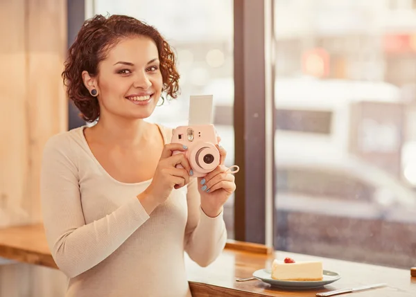 Smiling woman holding photo camera