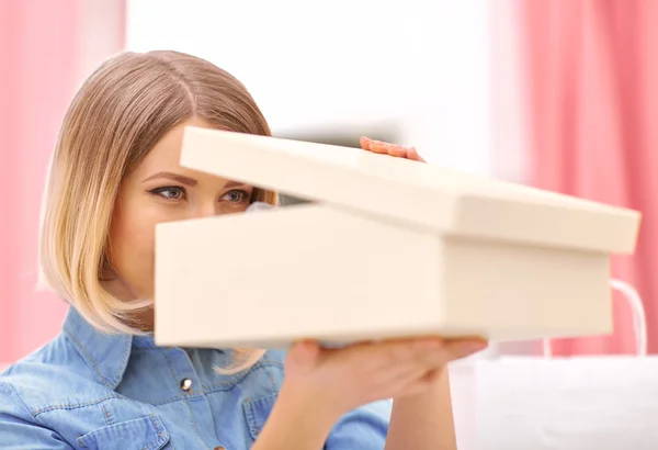 Pleasant woman opening box with shoes