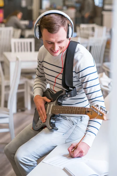 Cheerful guy playing the guitar