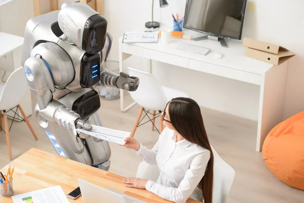 Nice girl working in the office with robot