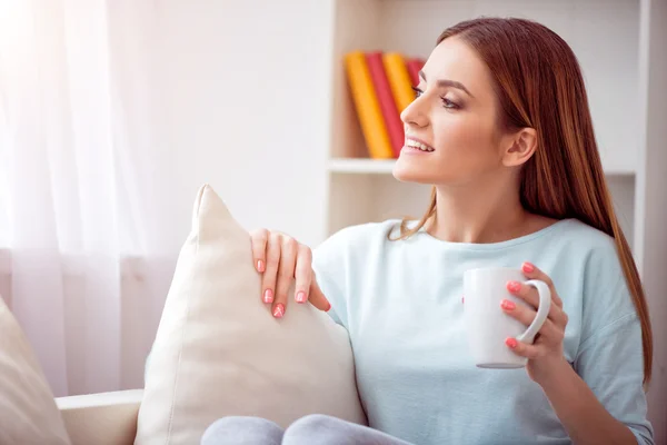 Pleasant delighted woman resting on the couch