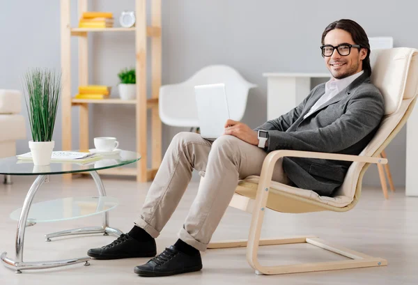 Delighted businessman sitting in the chair