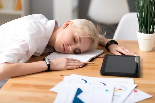 Woman sleeping on table while working