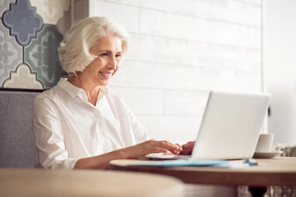 Cheerful delighted woman using laptop