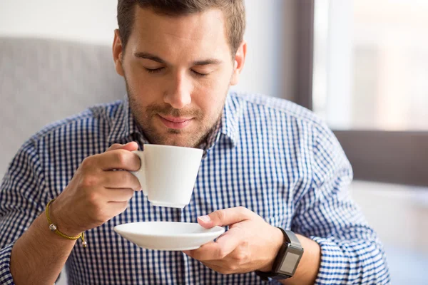 Delighted man drinking coffee