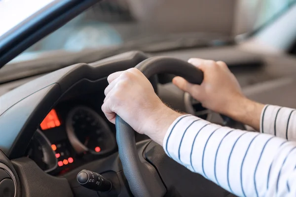 Close up of the hands on steering wheel