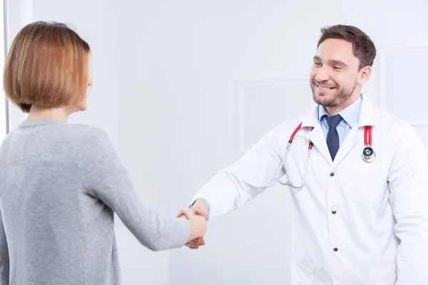 Nice doctor shaking hands with the patient