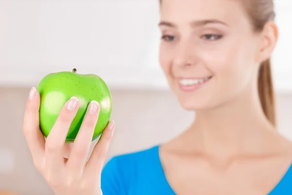 Delightful young woman holding apple