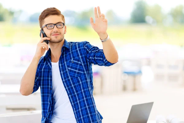 Pleasant guy holding mobile phone