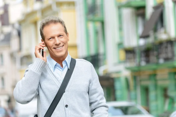 Smiling man holding mobile phone