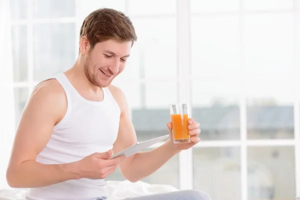 Man checks his planner while drinking juice.