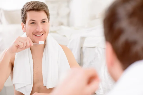 Man is about to brush his teeth.