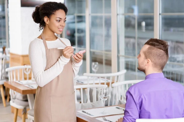 Waitress is busy taking an order.