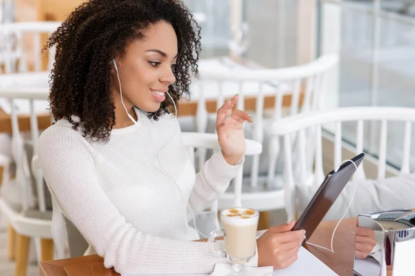 Young woman using tablet and headphones.