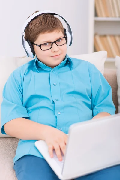 Chubby kid playing games on the laptop.