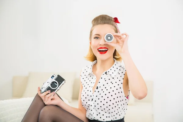 Young attractive girl playing with camera parts.