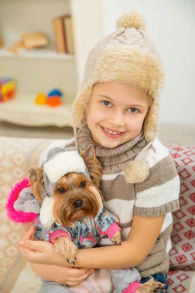 Little kid holding her pet Yorkshire.