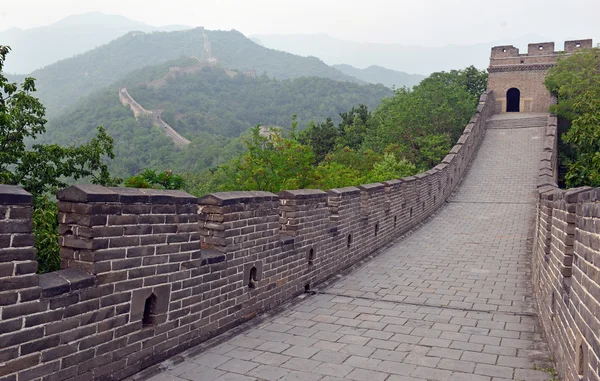 Great Wall of China atop the mountains in the forest, showing air pollution and smog, China