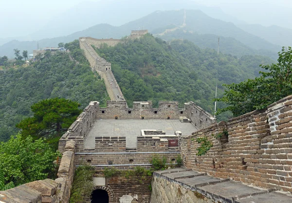 Great Wall of China atop the mountains in the forest, showing air pollution and smog, China