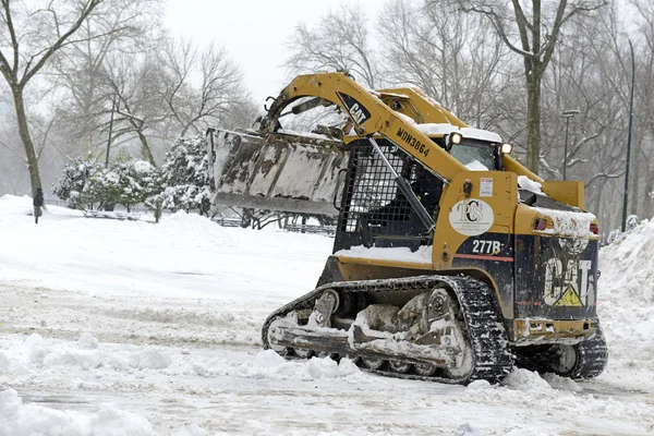 Construction equipment clearing snow on street after snowstorm