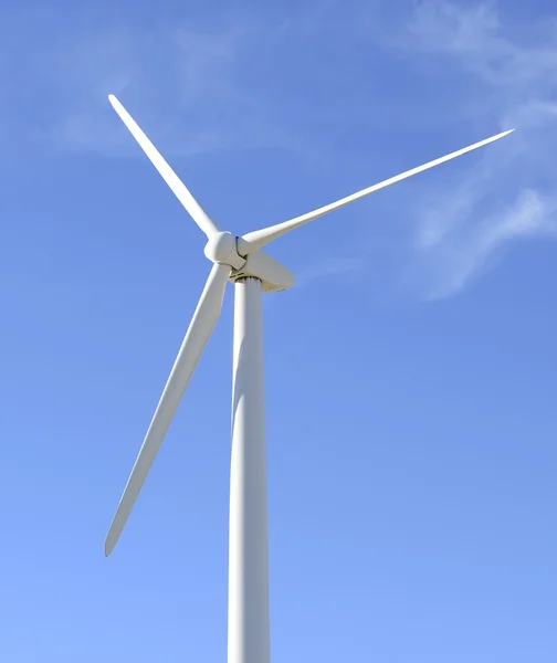 Alternative energy concept, wind turbine in desert landscape with blue sky