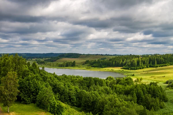 Green valley, views of the forest and the lake and sky with thunderclouds