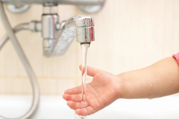 Child hands in the sheet of water