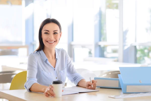 Positive businesswoman sitting at the table