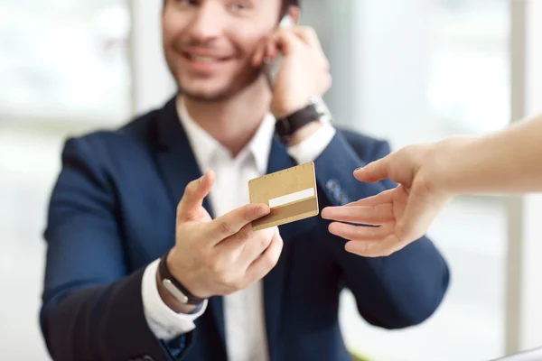 Handsome businessman giving credit card