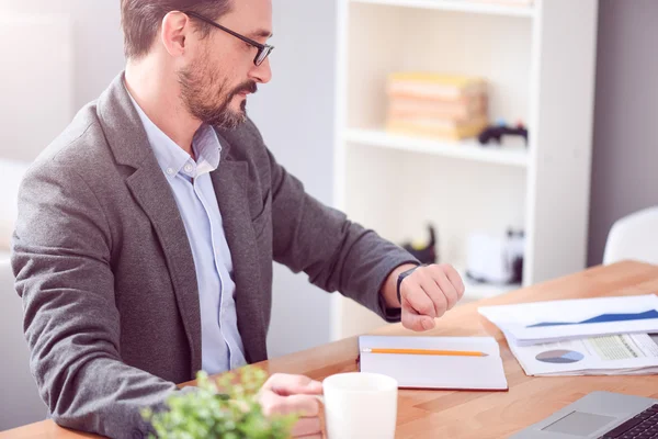 Man looking at watch while sitting