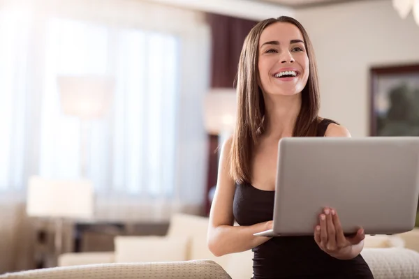 Woman smiling and holding laptop
