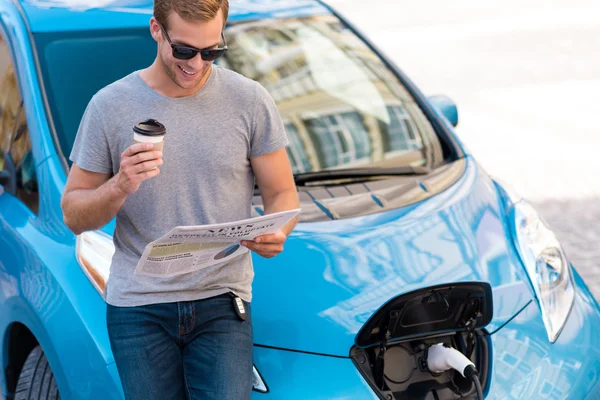 Man reclining on his hybrid car