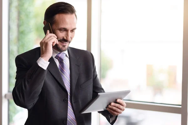 Positive businessman talking on cell phone