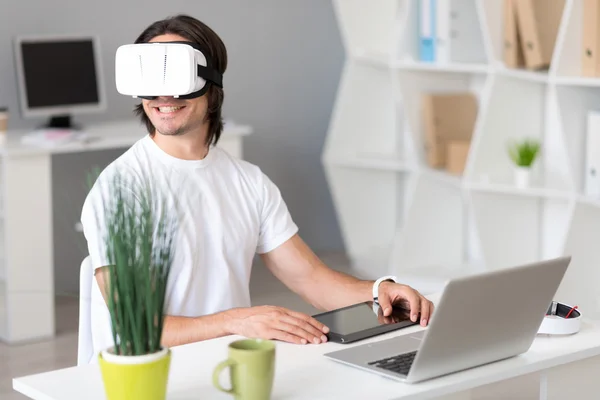 Cheerful man using virtual reality glasses