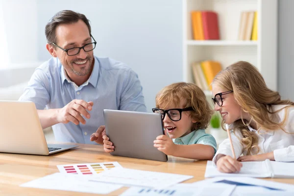 Man with children looking at tablet