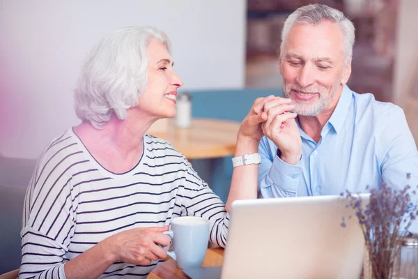 Positive loving senior couple resting in the cafe