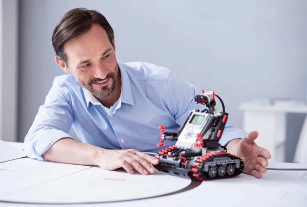 Handsome man with a beard using  robot