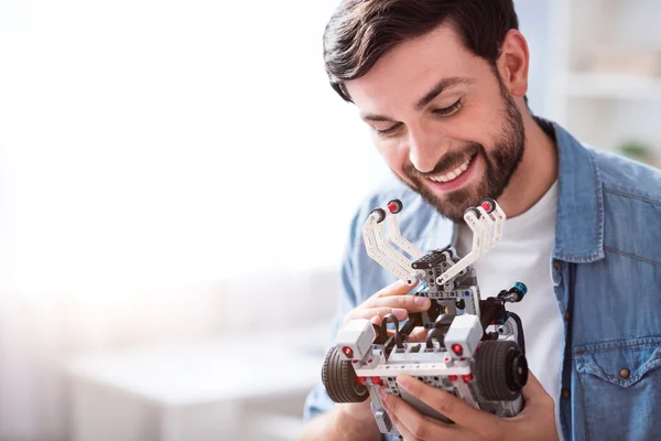 Joyful man holding robot