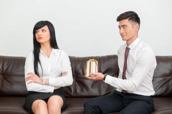 Business couple sitting on sofa in office