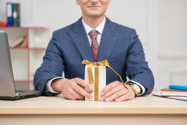Businessman in office with present box