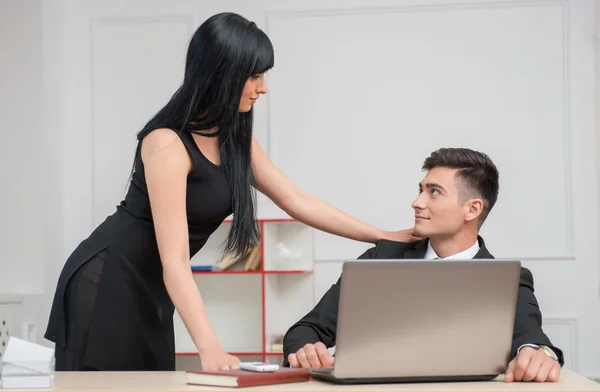 Business couple looking to each other with love in office