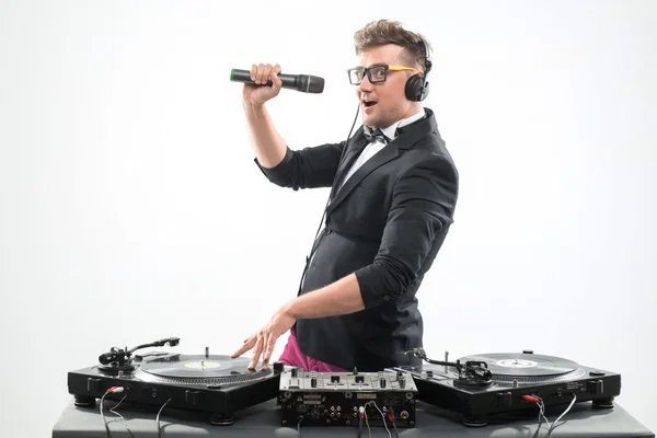 DJ in tuxedo having fun and dancing with microphone by the turnt