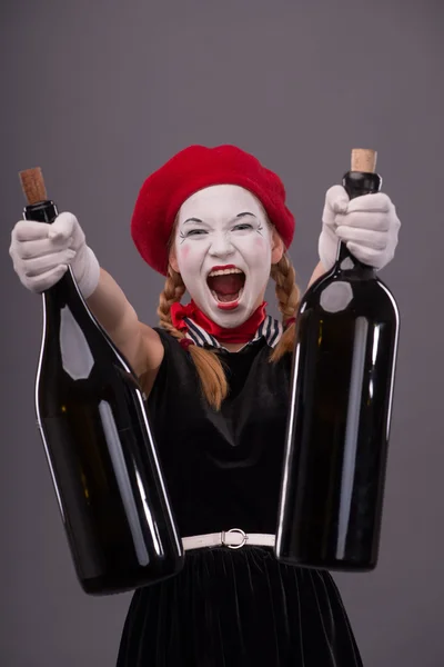 Portrait of young mime girl holding big bottles in her hands iso