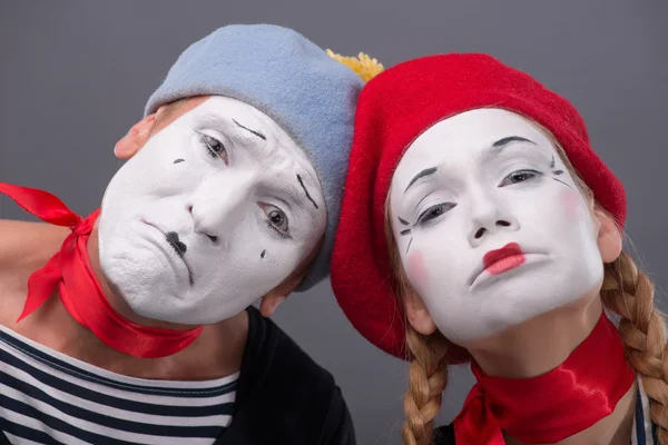 Portrait of sad mime couple crying isolated on grey background