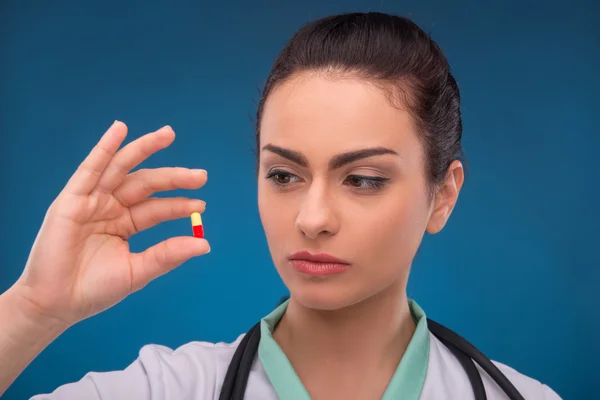 Woman doctor holding pill