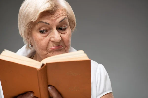 Elderly woman holding yellow book