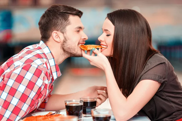 Woman and man eating one piece of pizza